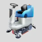 Une machine bleue et blanche avec des roues sur le sol. Alt : Autolaveuse Autoportée Fiorentini ECOSMILE 100 48V 150L. Rendement jusqu'à 5750 mq/h, autonomie de 5h, capacité de réservoir de 150L, vitesse d'avancement de 0-6km/h, moteur d'aspiration de 750W, moteur à brosse de 2x400W, moteur de traction de 500W. Largeur utile de travail de 960mm, production horaire maximale de 5750 m²/h, traction de face. Dimensions de 140x105x136cm, poids de la machine de 178 kg, poids de la batterie de 4 x 37 kg.