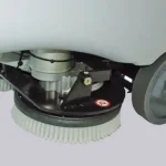Une machine de nettoyage de sol bleue et grise avec des roues pour un rendement jusqu'à 4000 mq/h et une autonomie de 4 heures. Capacité réservoir solution : 110L. Vitesse d'avancement : 0-6 km/h.